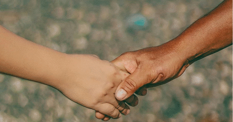 Adult and child holding hands