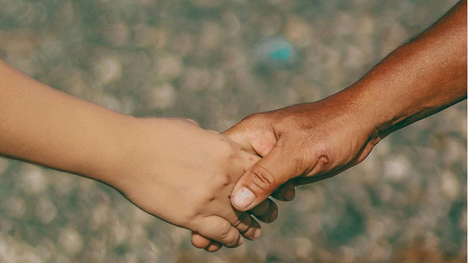Adult and child holding hands